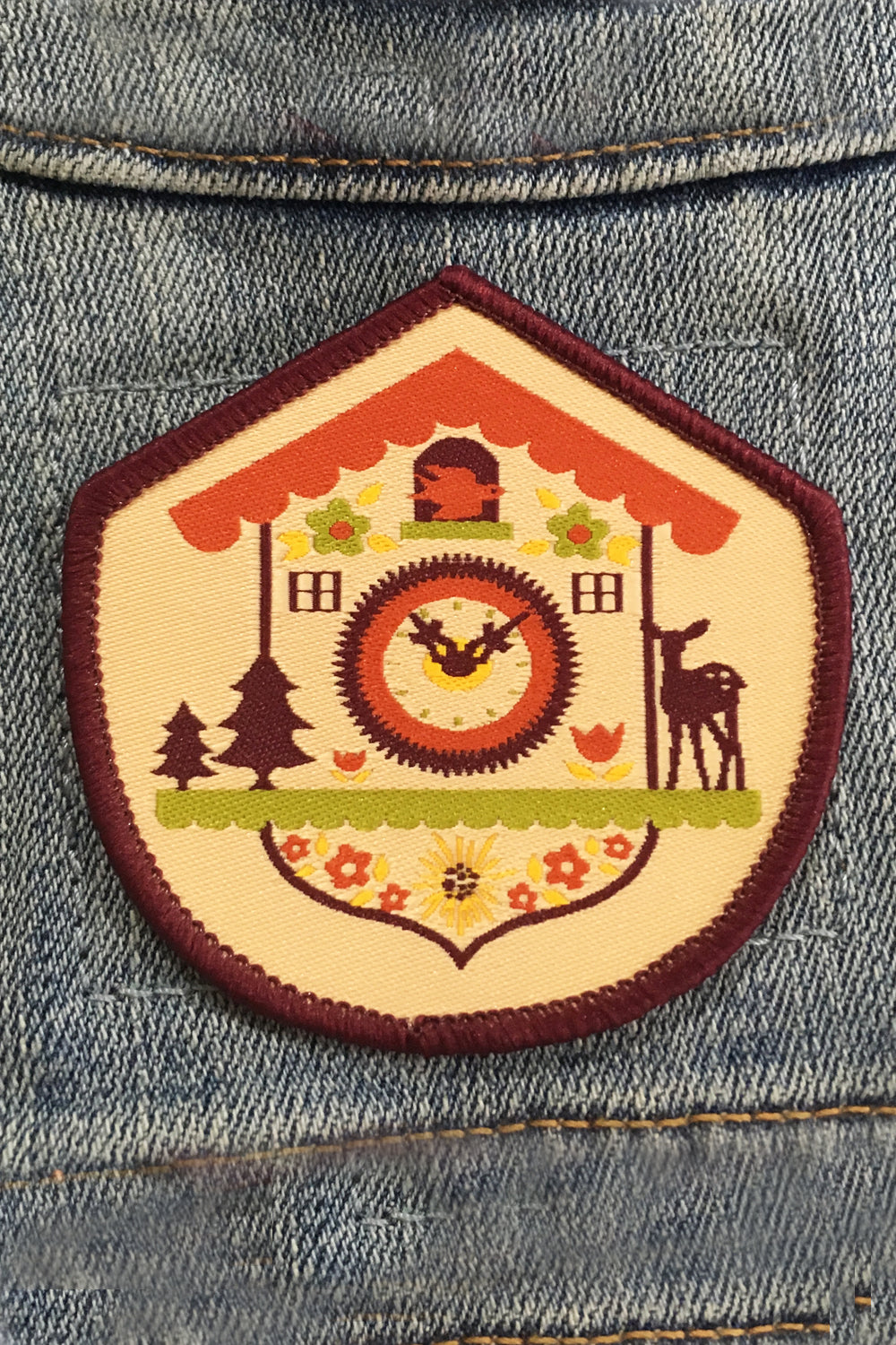 Purple, lime, yellow and red woven patch with a Bavarian cuckoo clock and purple border