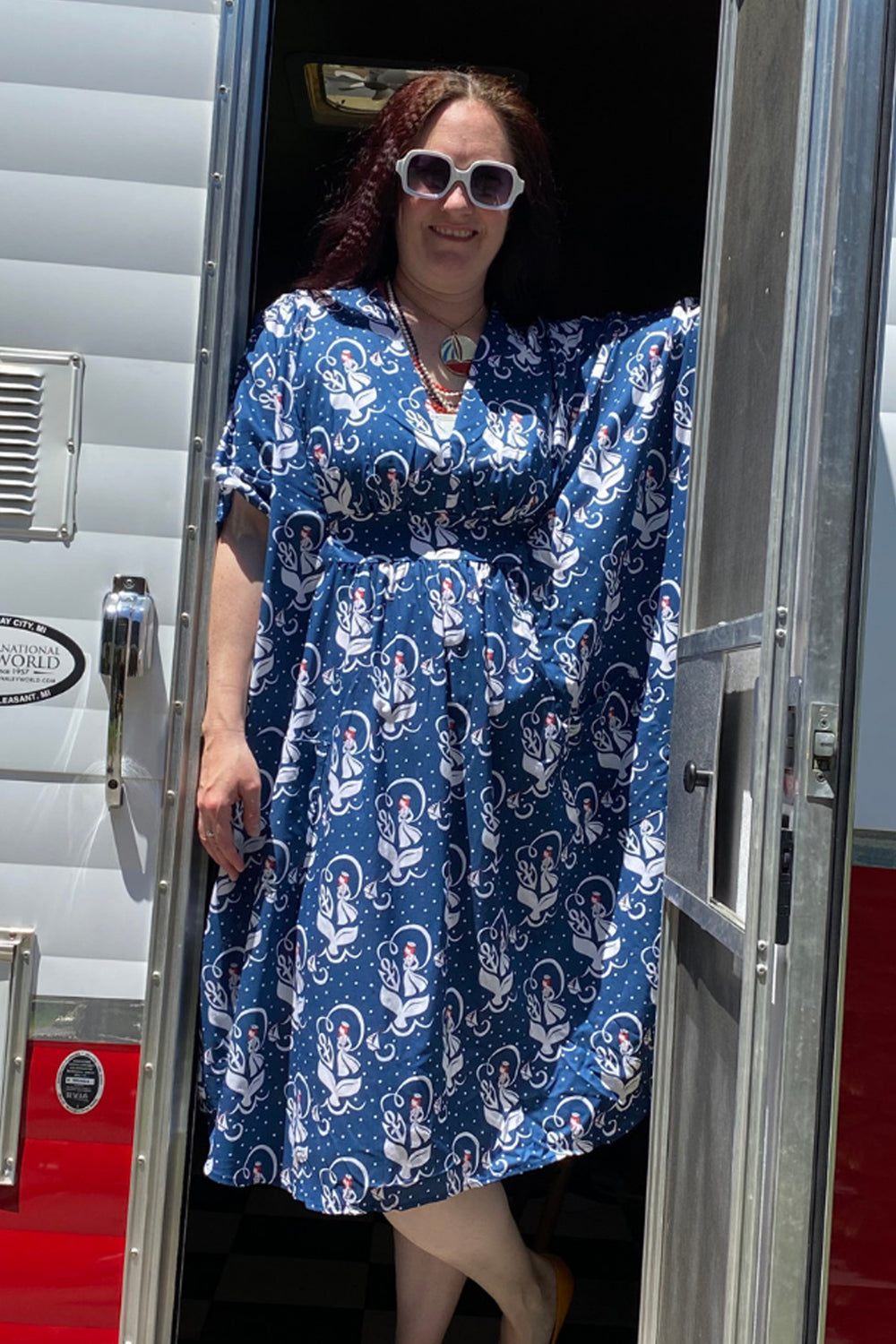 Woman in sunglasses and navy, red, and white v-neck nautical pocket midi caftan