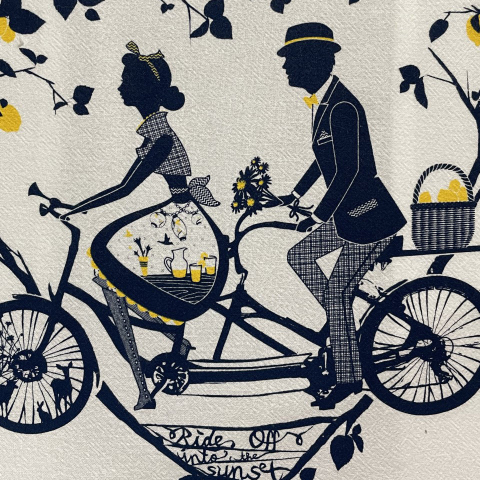 Tea towel featuring an older couple riding a tandem bicycle