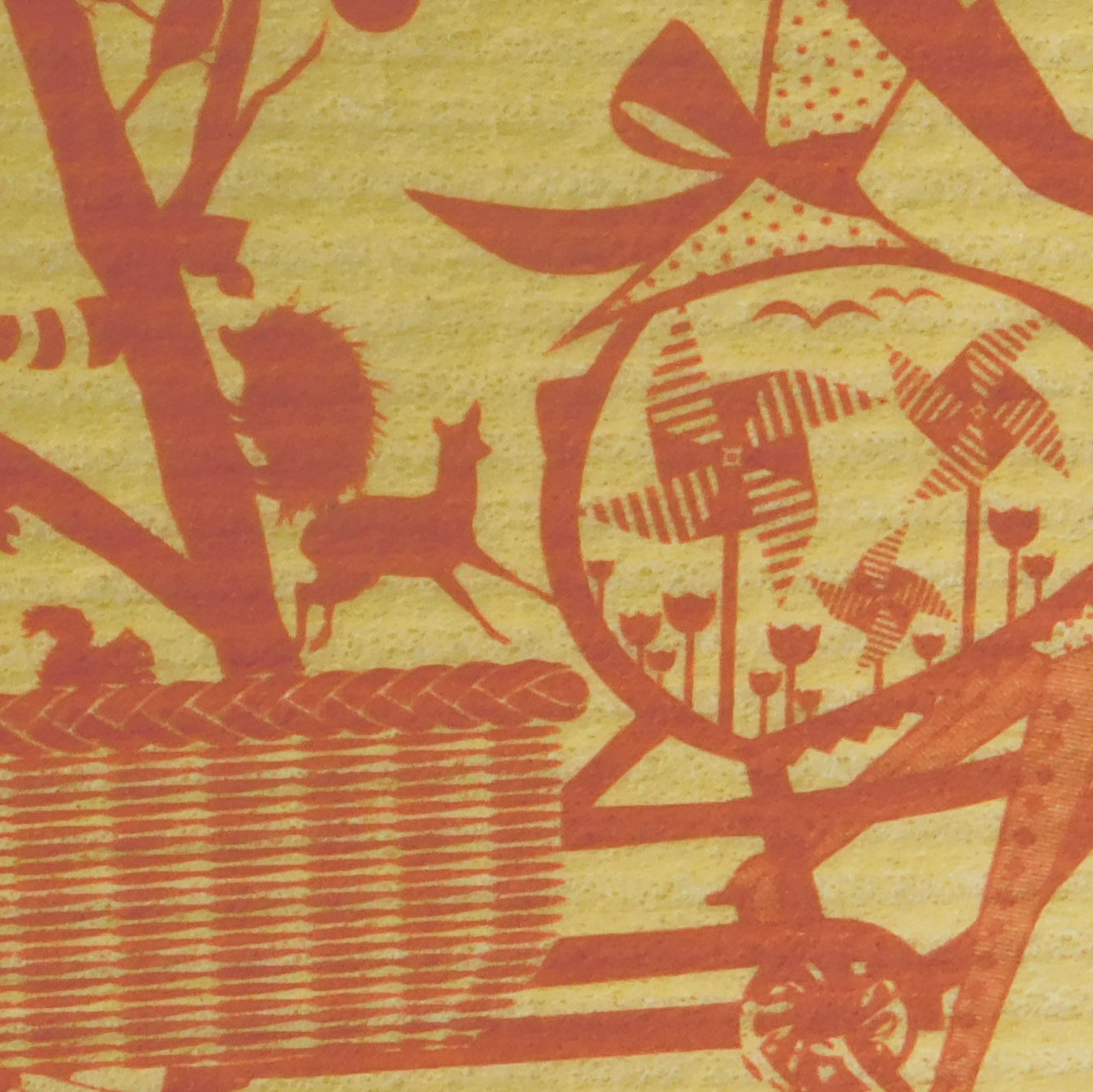 Closeup of yellow Swedish dishcloth with red graphic of girl on bicycle