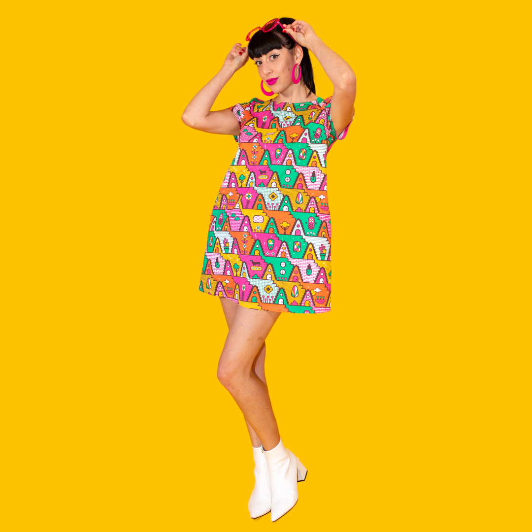 Dark-haired model in bright multicolored geometric pocket tunic with ankle boots