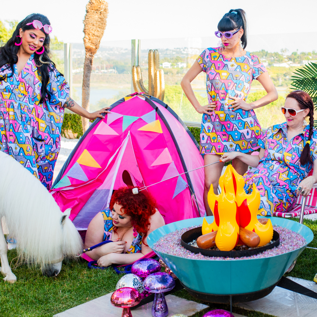 4 girls in matching geometric print clothing hanging out around an inflatable campfire