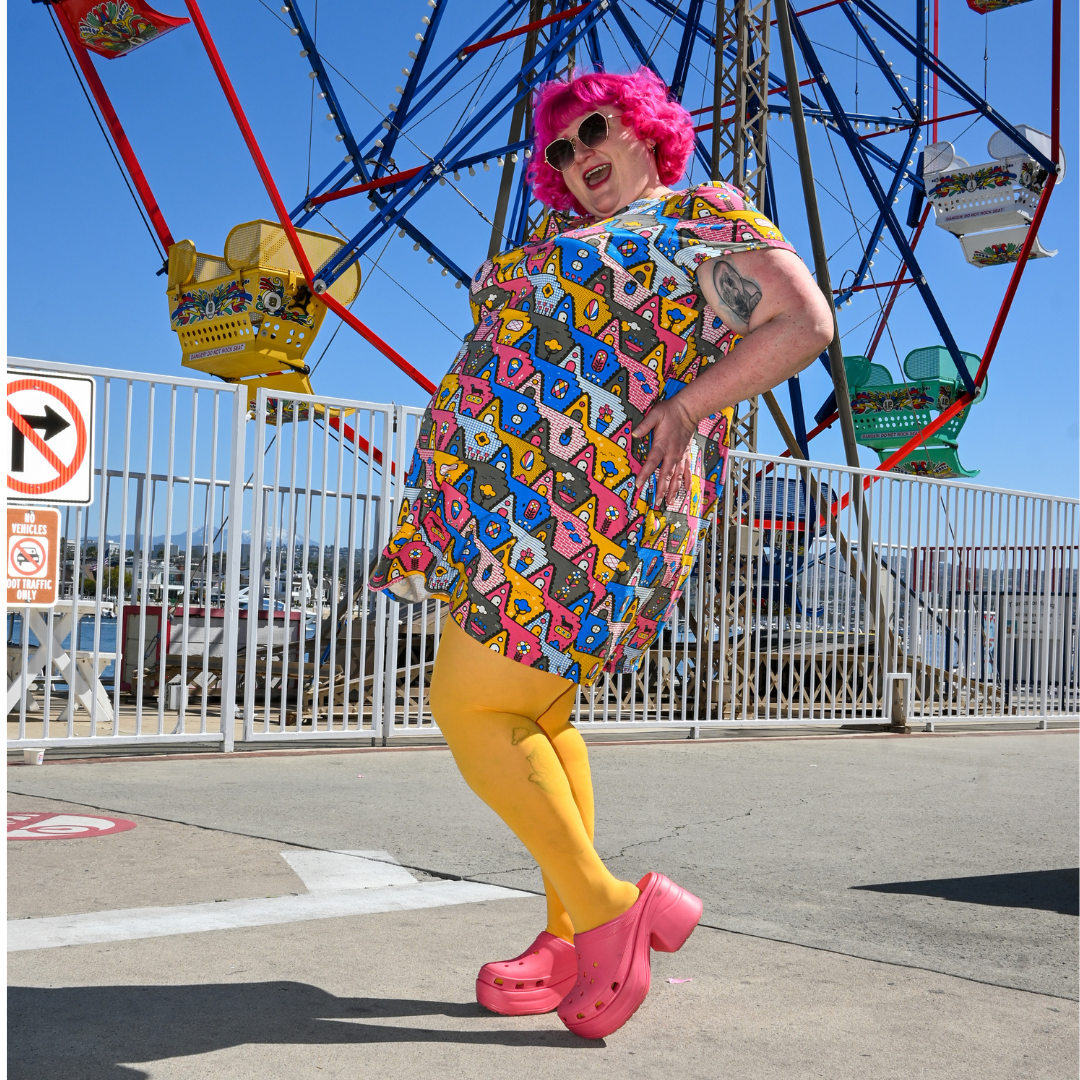 Side view of fun pink-haired model in geometric print pocket tunic