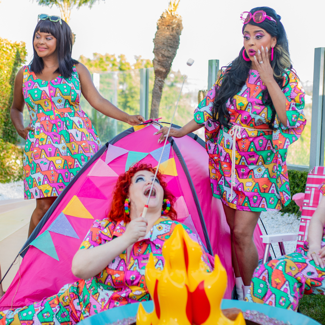 3 girls dressed in matching geometric print clothing having fun with camping accessories