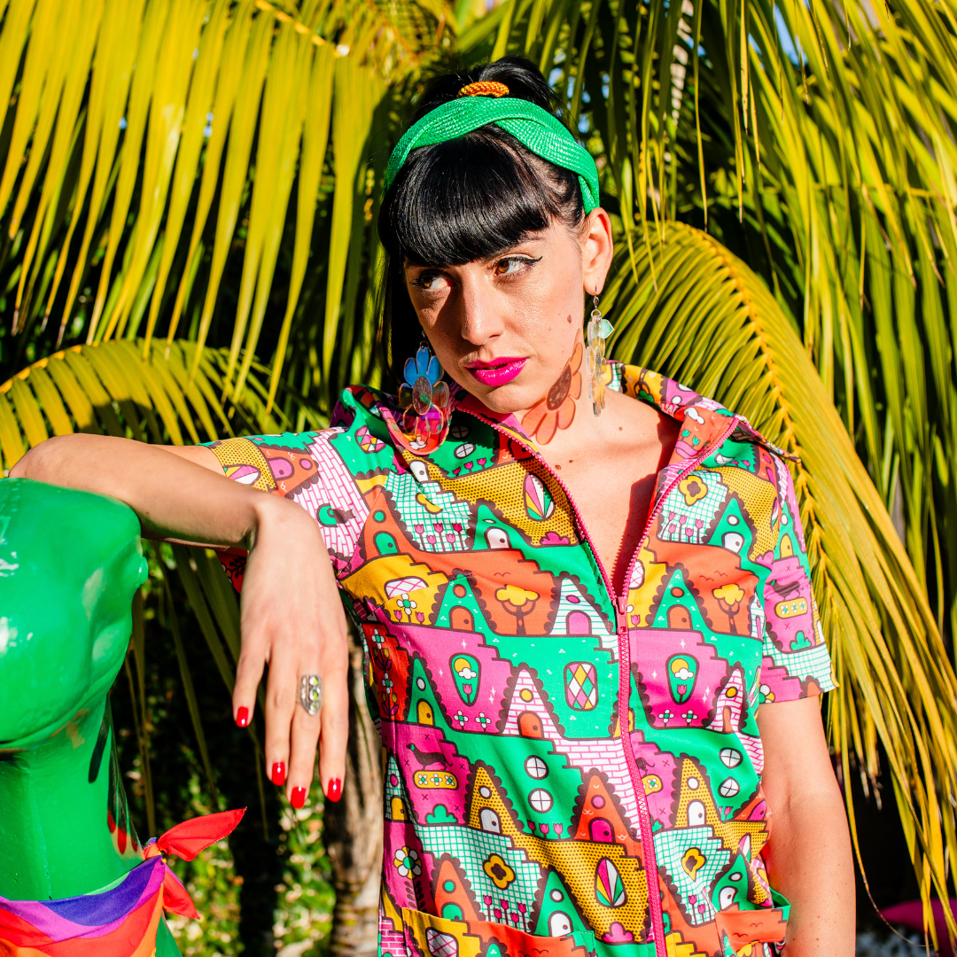 Closeup of model in bright colored geometric jumpsuit and green headband