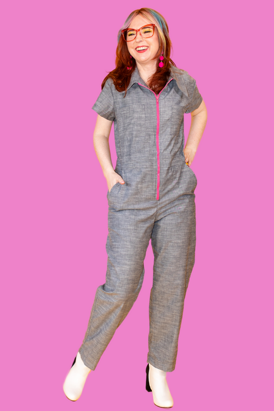 Young woman in glasses and chambray jumpsuit with bright pink zipper