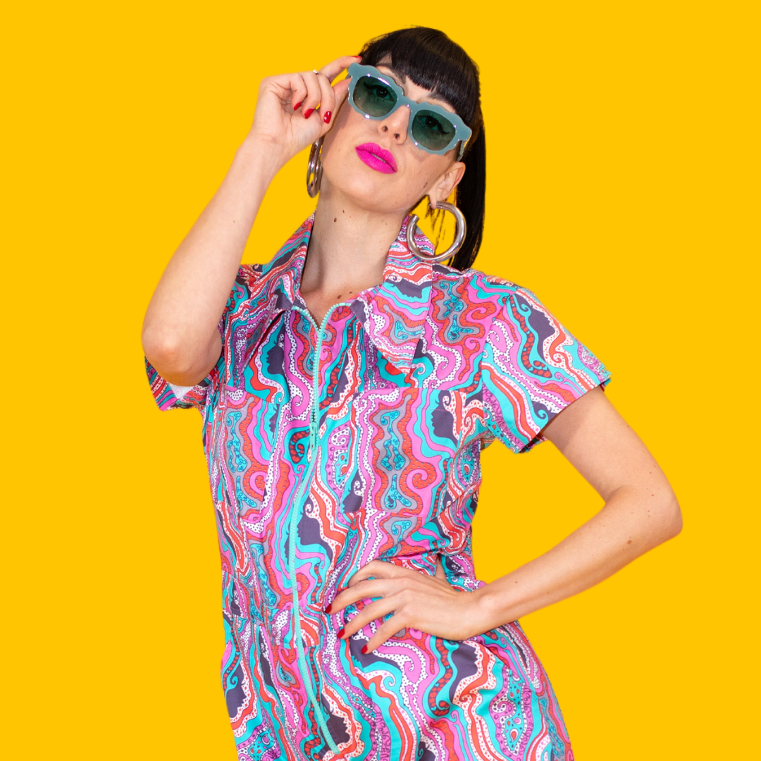 Closeup of dark-haired sexy model in bold psychedelic printed groovy jumpsuit