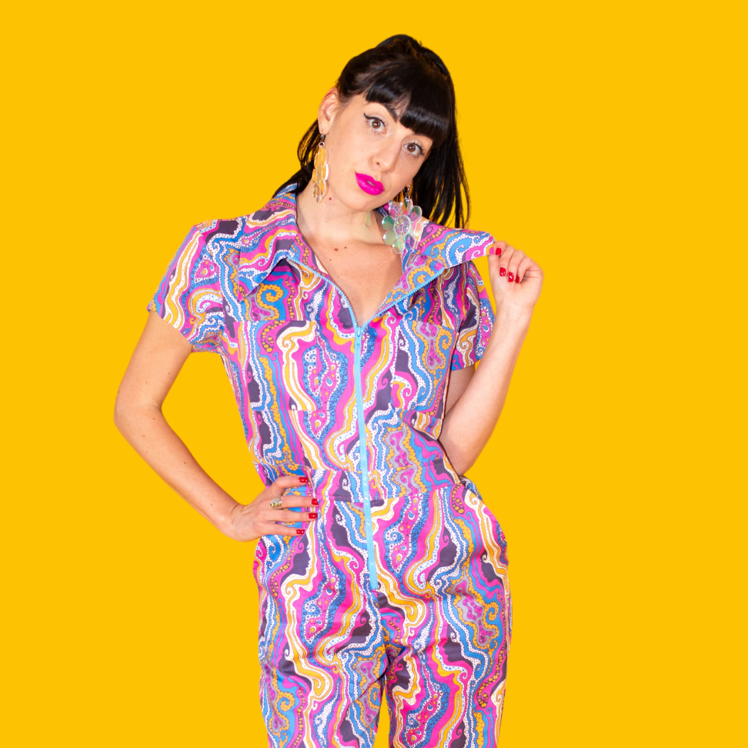 Closeup of model in bright lipstick and bold psychedelic print jumpsuit