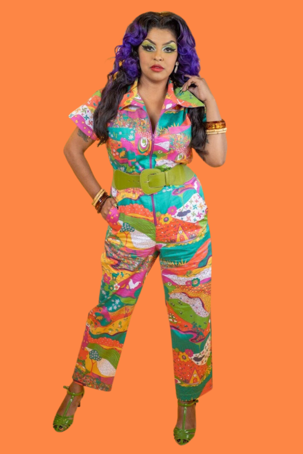 Purple-haired model in bright colored printed jumpsuit with belt