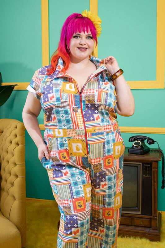 Pink haired model wearing colorful jumpsuit with a patchwork design