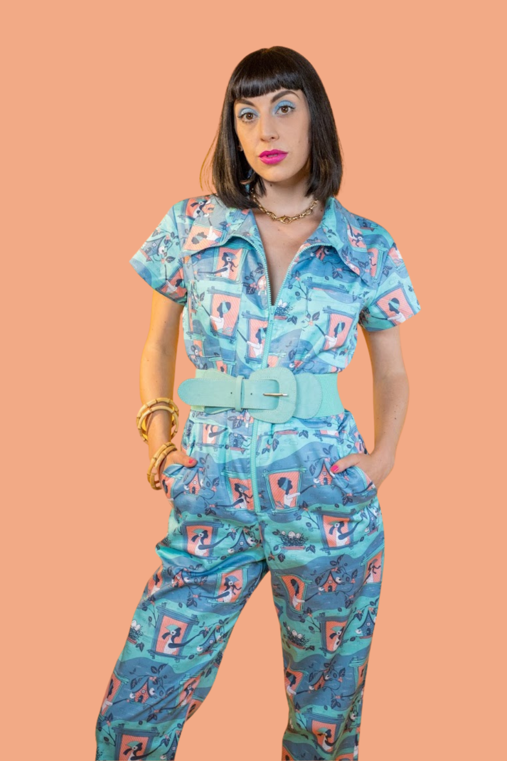 Model in peach, aqua and grey jumpsuit with print of girls and birdhouses