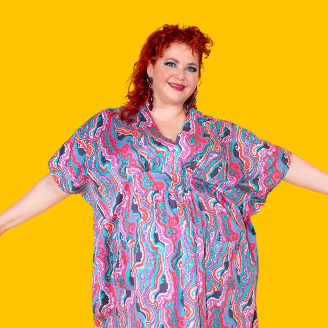 Red-haired model in bold psychedelic print maxi caftan, closeup