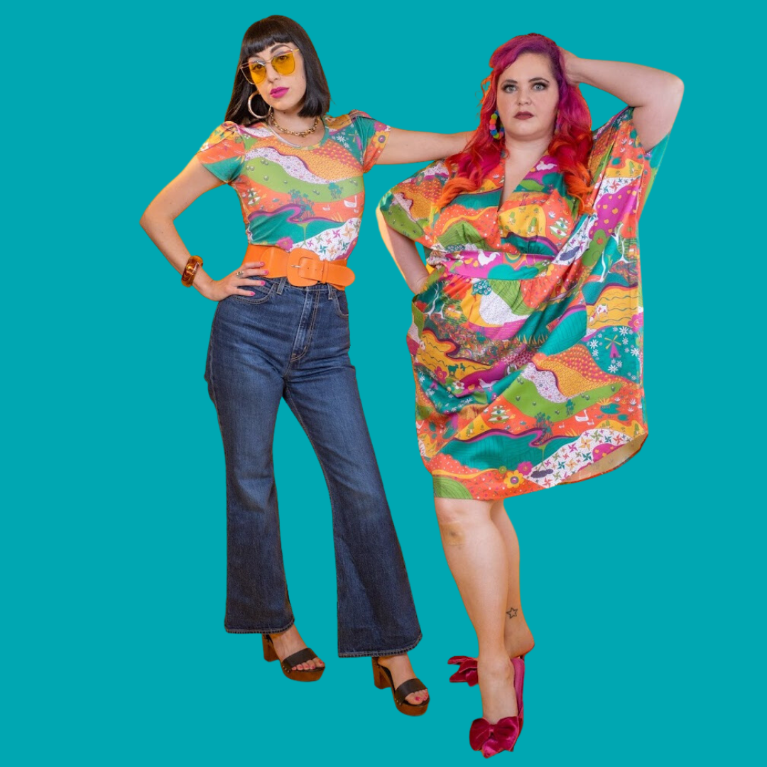 Black-haired model in bright, colorful printed tee and pink-haired model in bright, colorful caftan