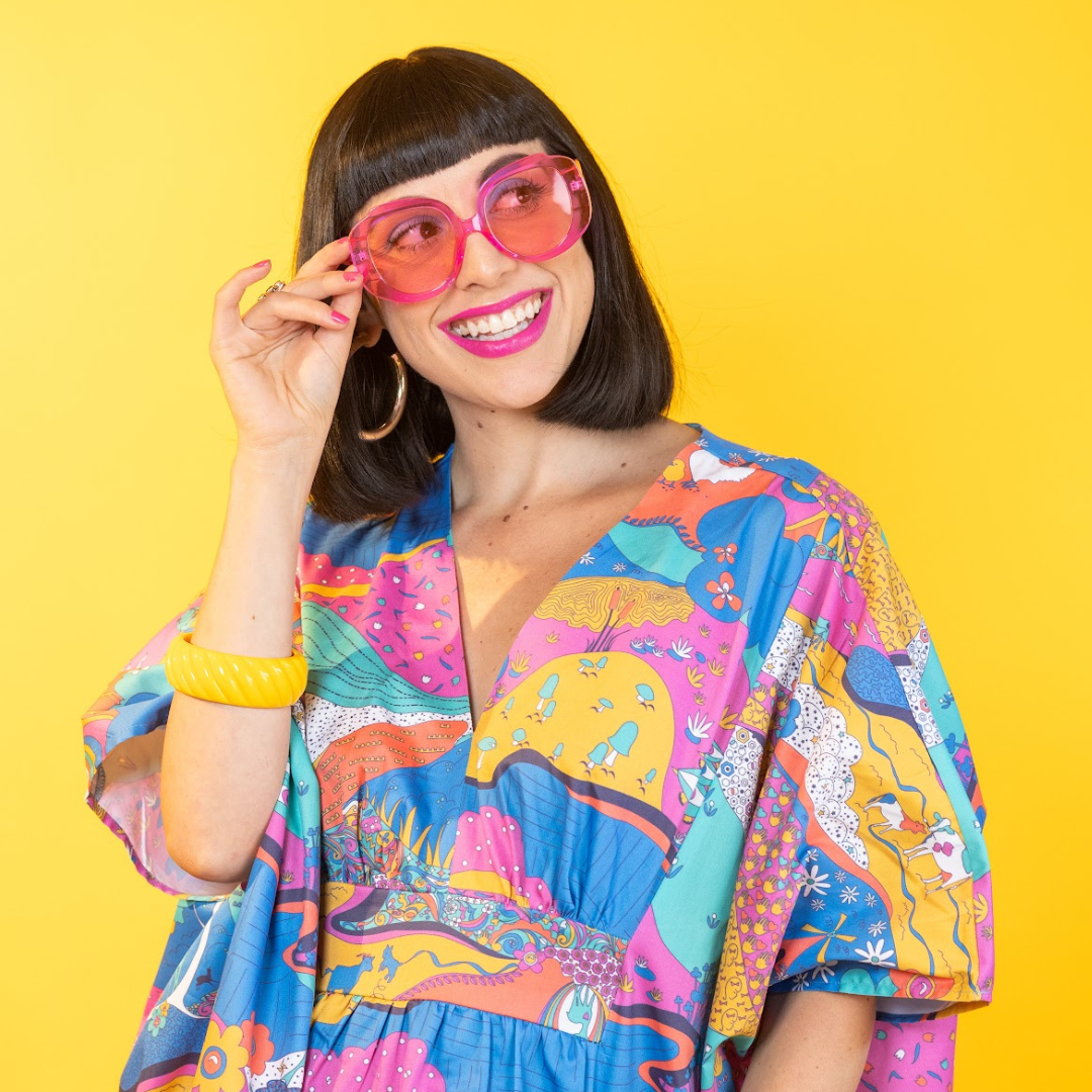 Model in sunglasses and bright, colorful cotton caftan dress