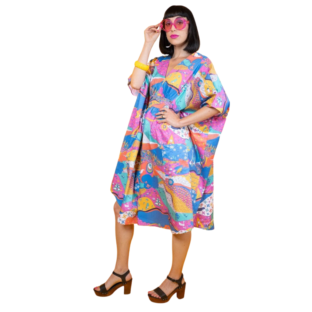 Black-haired model in colorful caftan printed with animals and other natural elements