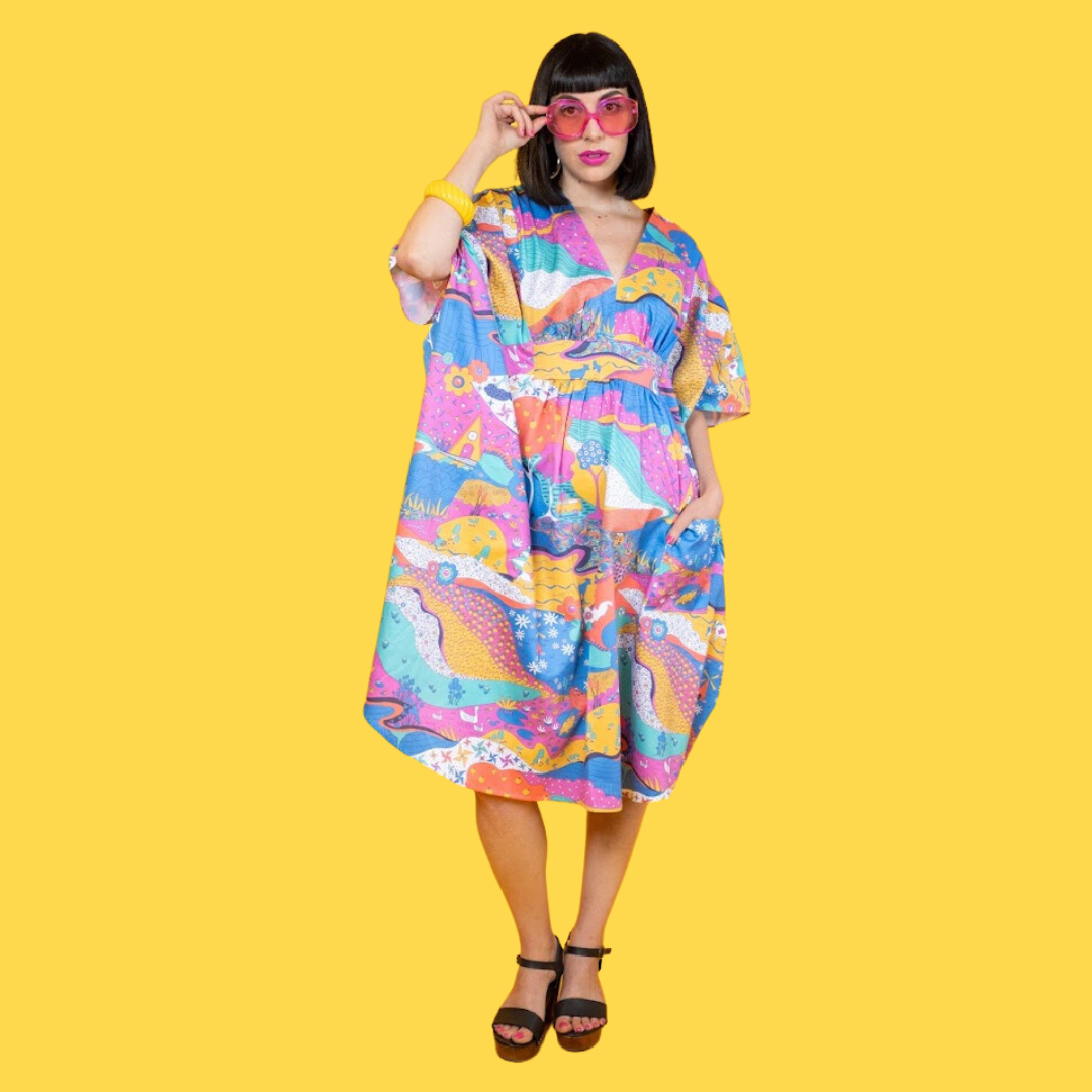 Black-haired model in colorful caftan printed with animals and other natural elements