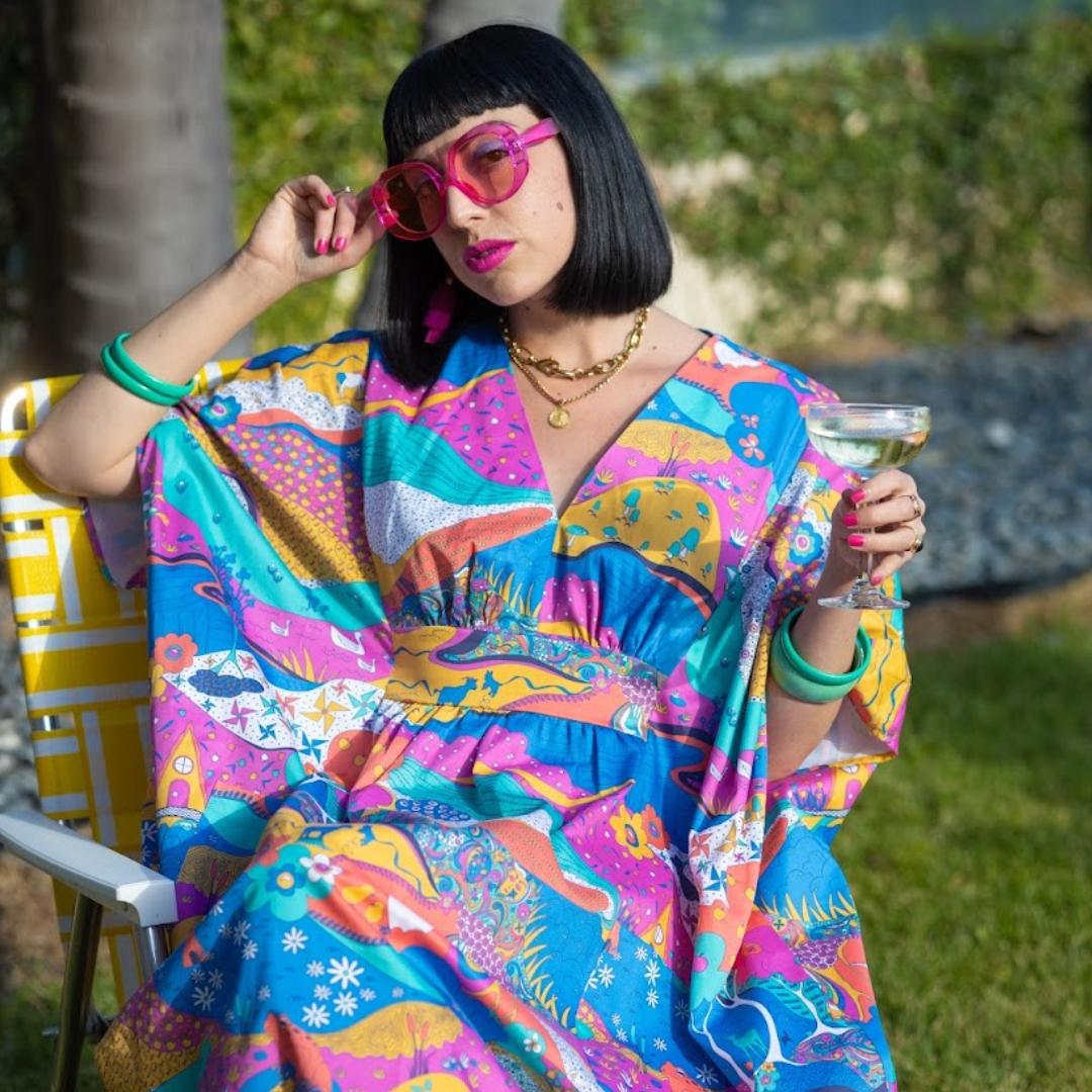 Black-haired model in colorful caftan printed with animals and other natural elements