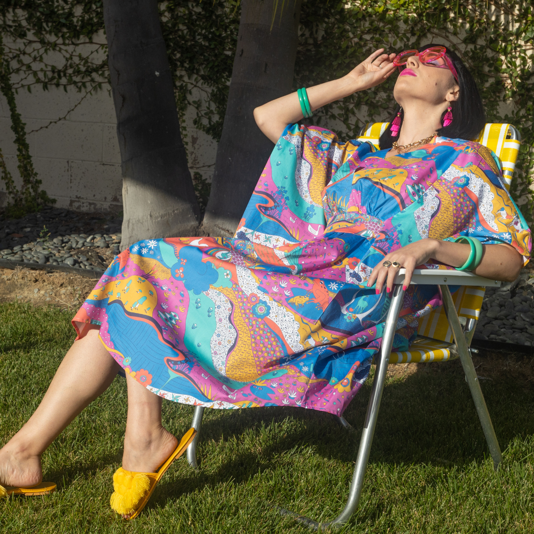 Model in colorful caftan lounging in lawn chair