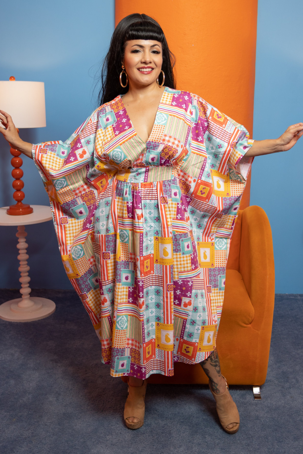 Dark haired model wearing a colorful dress with a patchwork design