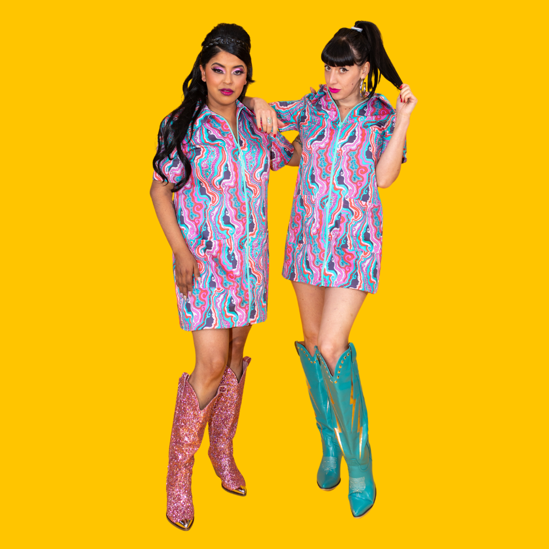 Full body view of 2 girls in psychedelic print minidresses