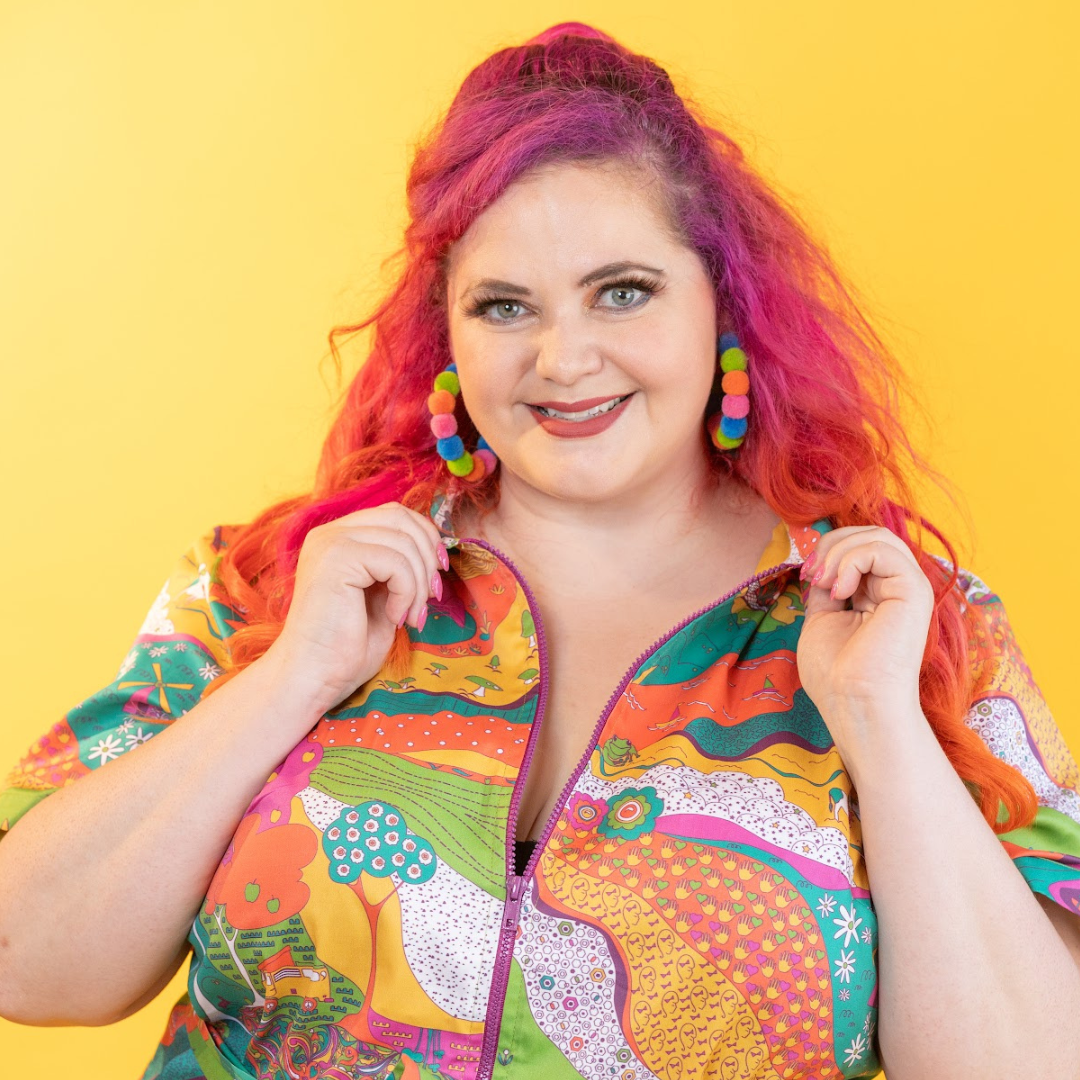 Pink-haired model in brightly colored printed belted minidress , closeup