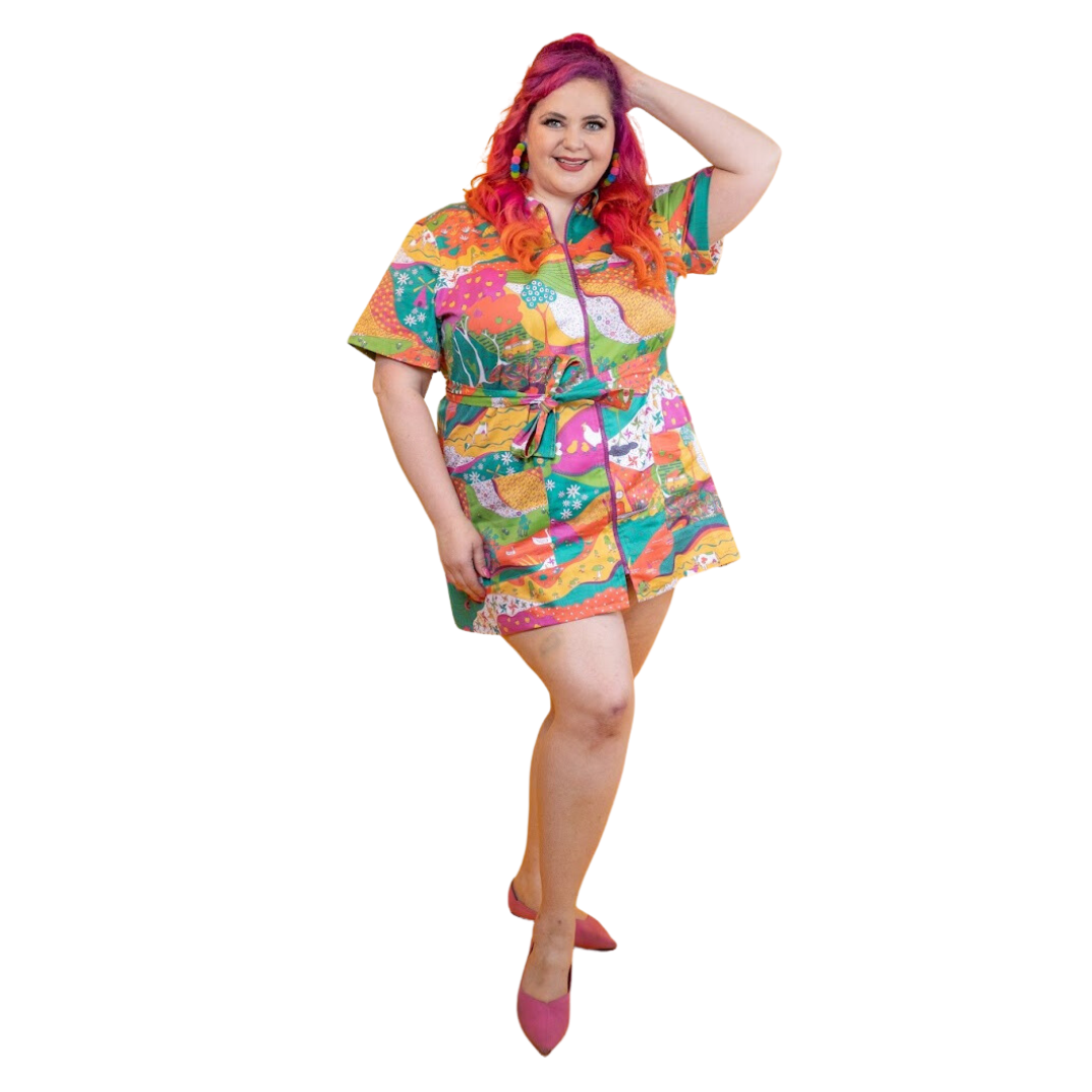 Pink-haired model in brightly colored printed belted minidress 