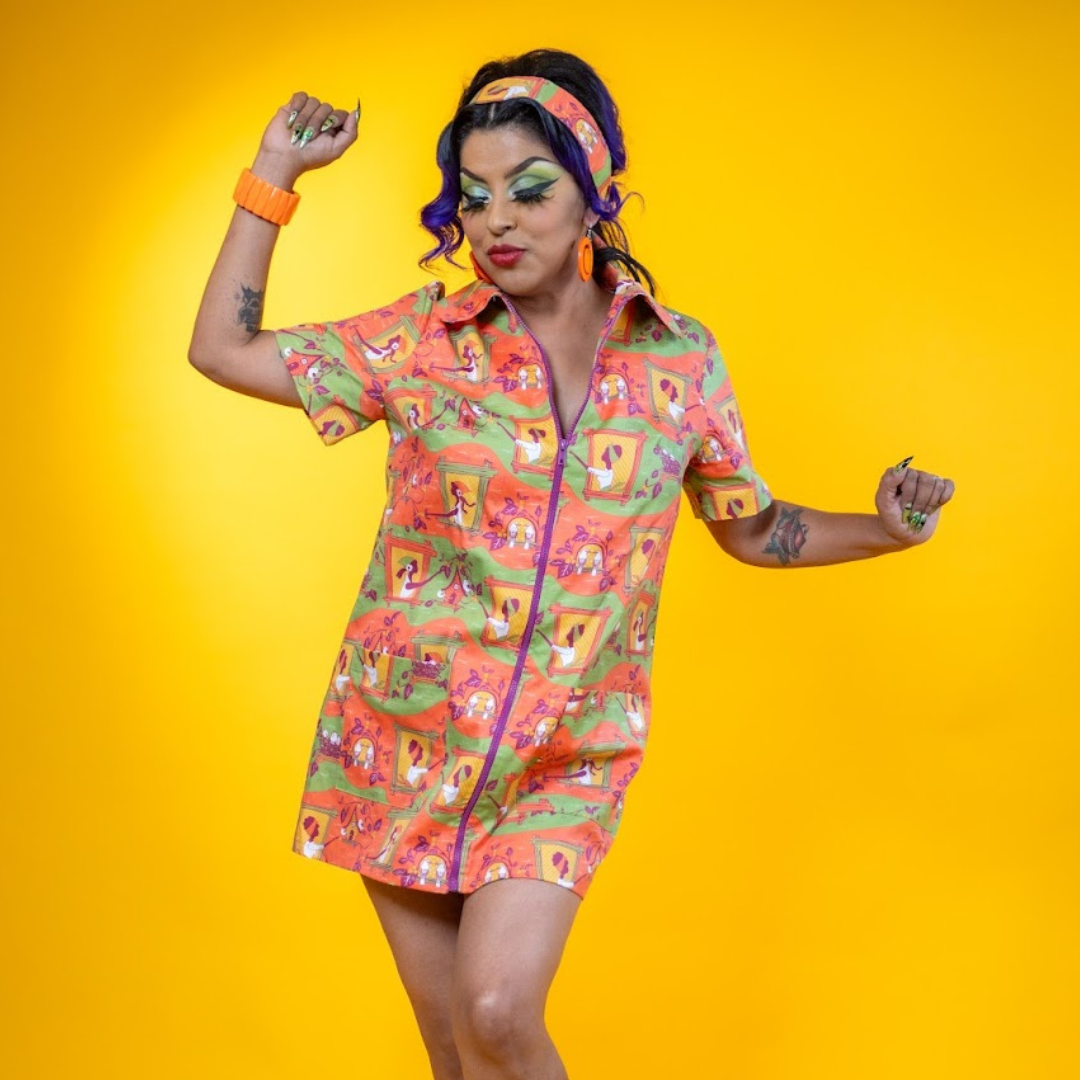 Latina model dancing in orange and green collared minidress