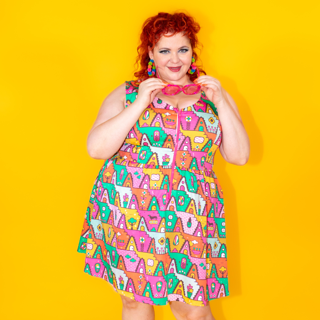 Closeup of fun red-haired model in brightly colored zip-front fit and flare dress