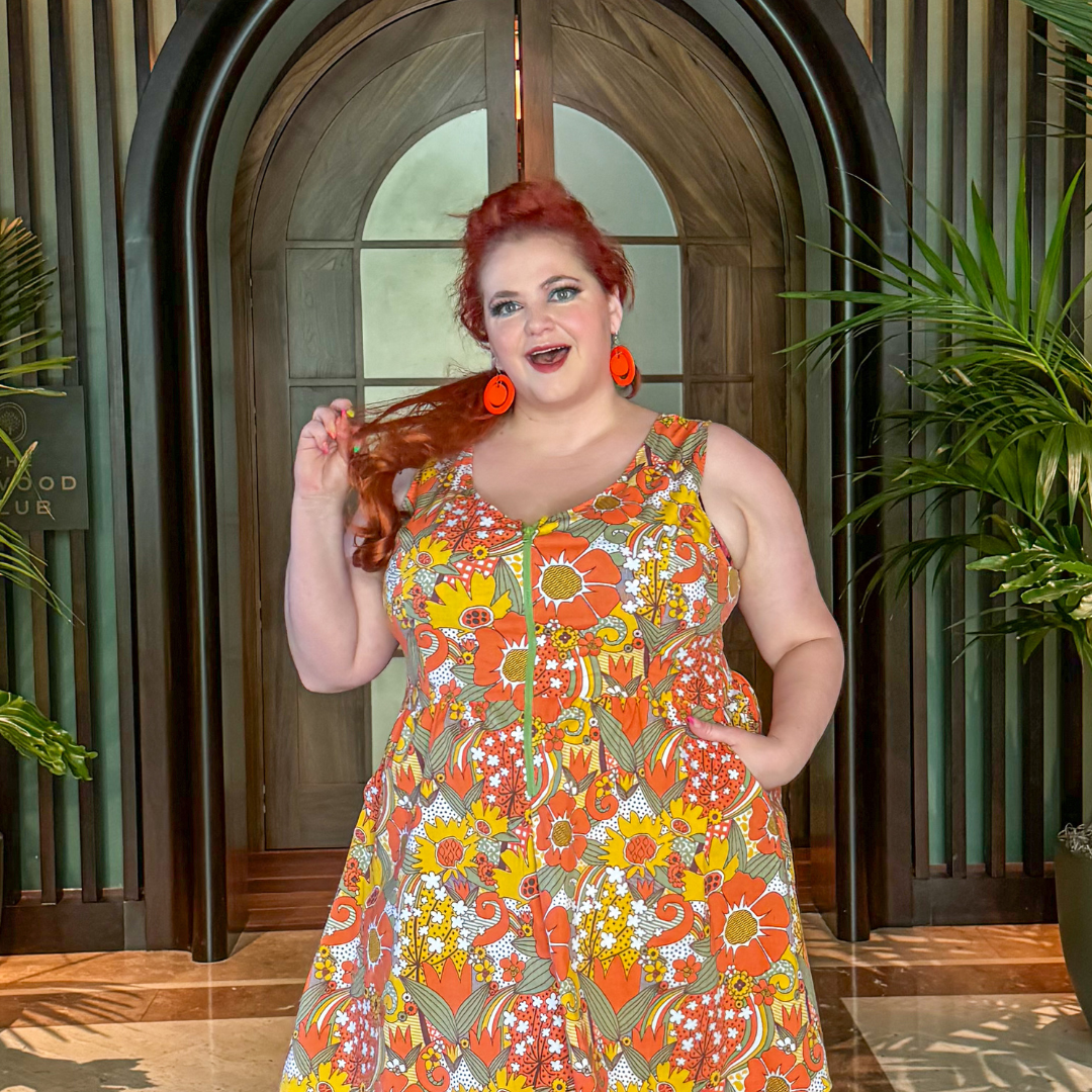 Closeup of red-haired model  in sleeveless retro flower print dress