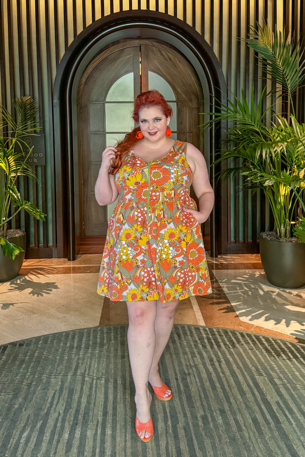 Red-haired model  in sleeveless retro flower print dress