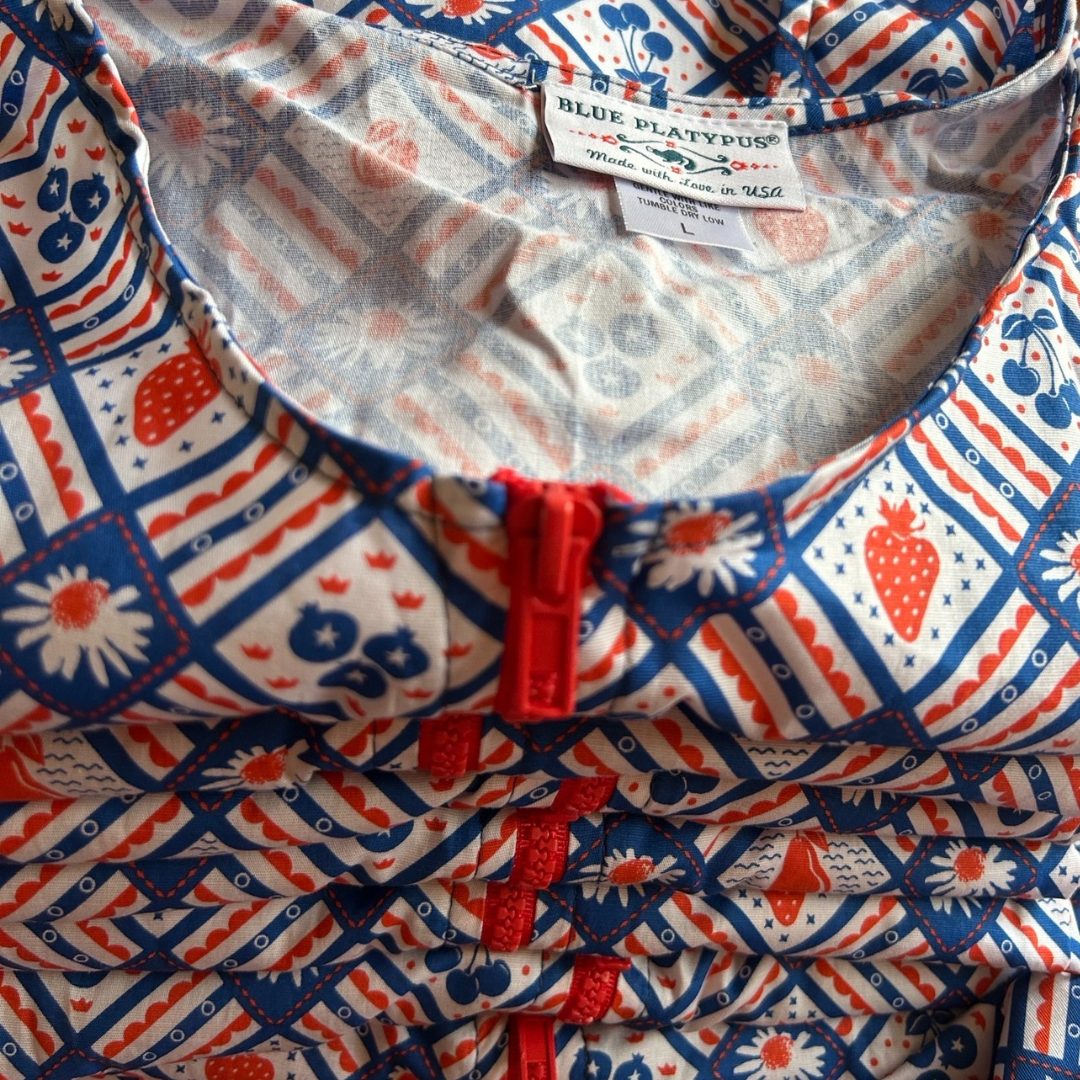 Close up of fabric of red white and blue dress with graphic of fruit and flowers