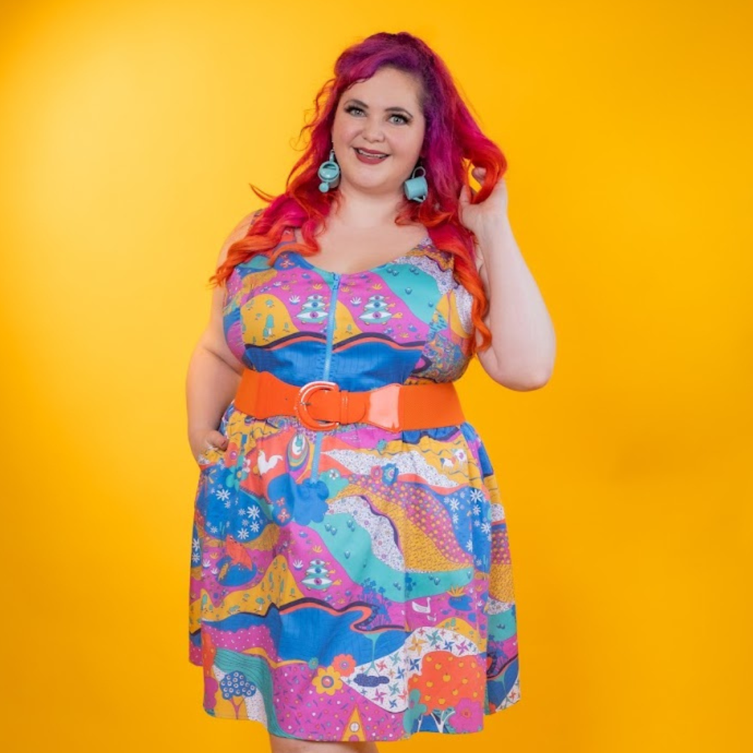 Red-haired model in colorful dress on a yellow background