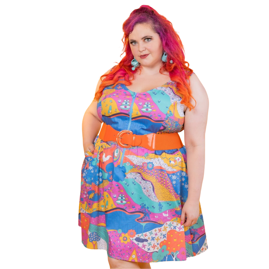 Red-haired model in brightly colored scoopneck dress with retro print and fun earrings