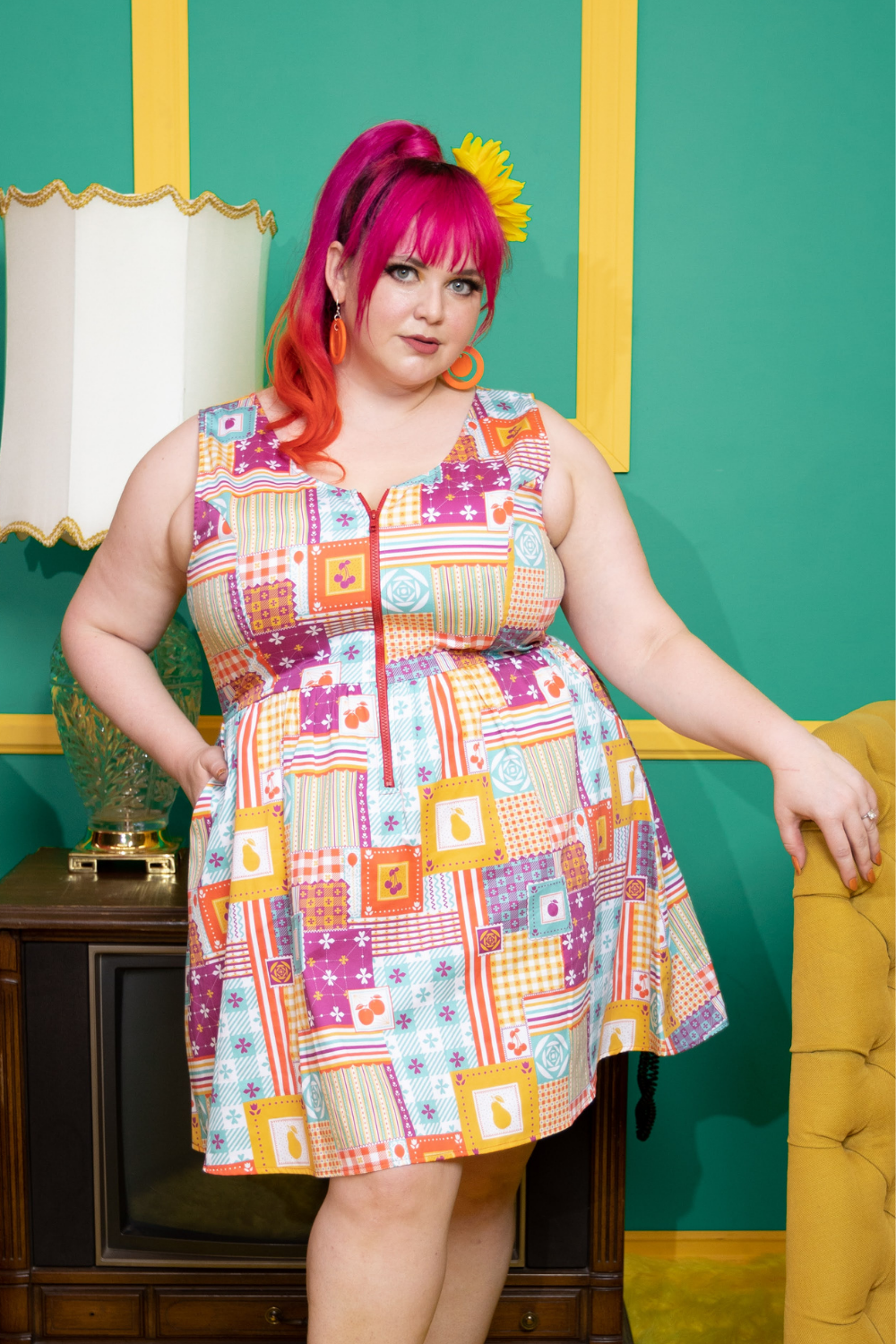 Pink haired model wearing colorful dress with a patchwork design