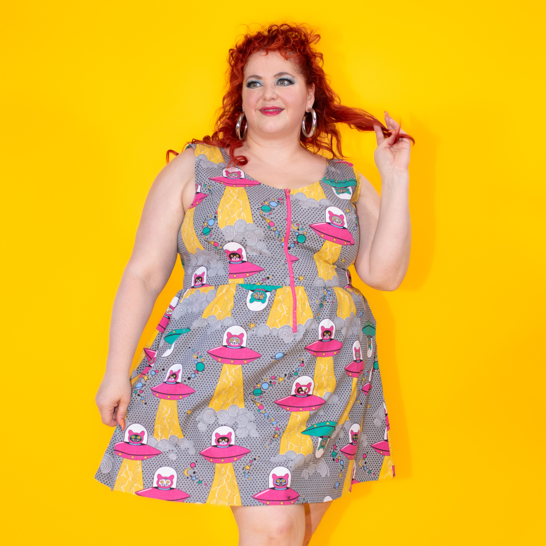 Red-haired model in grey dress featuring cats in space