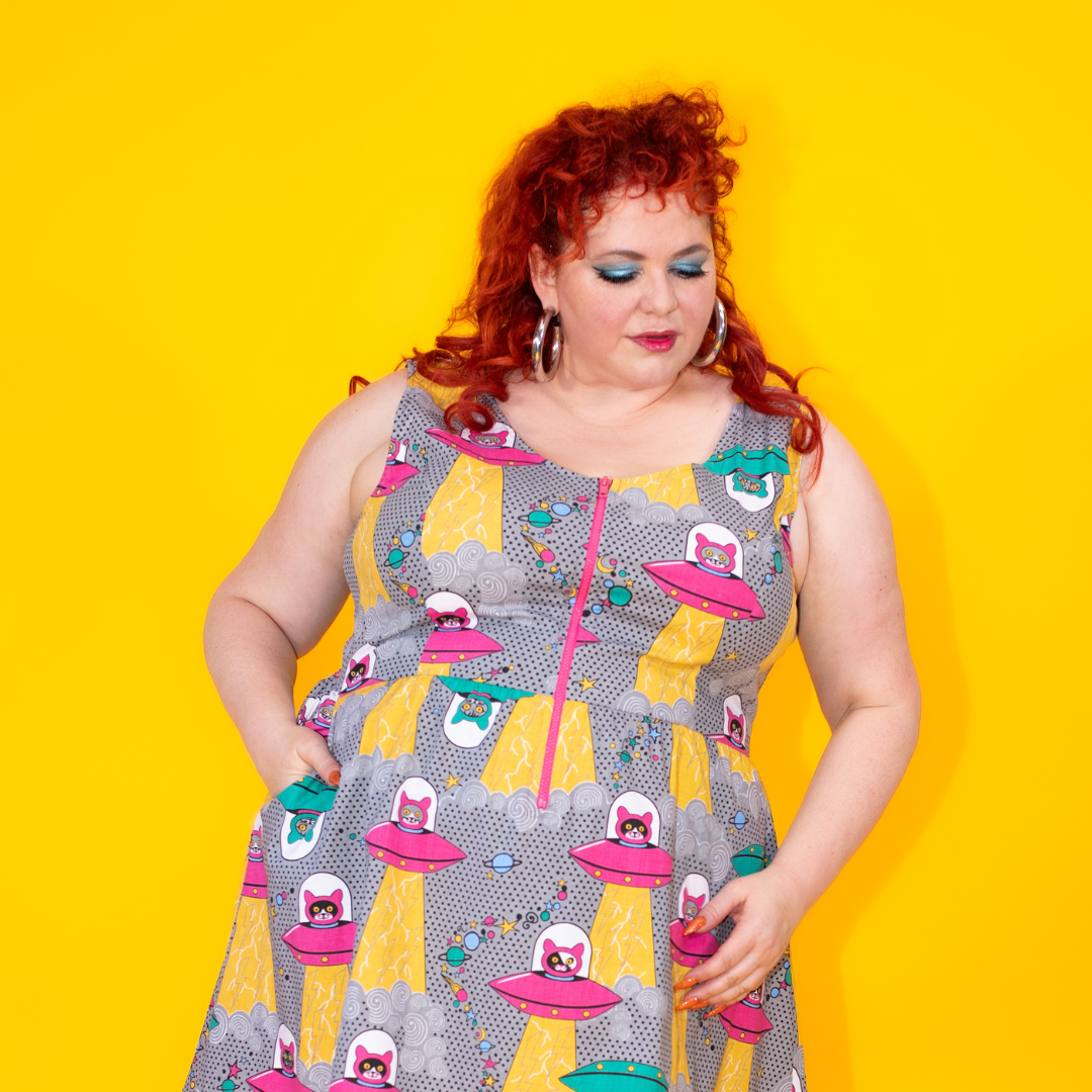 Closeup of model in dress with print of cats in spaceships