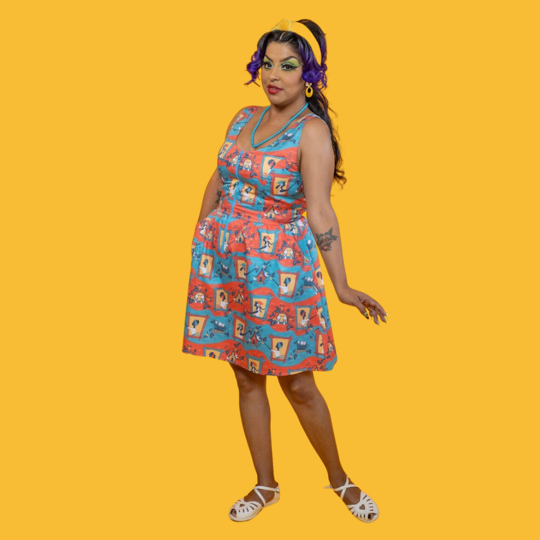 Side view of model in red, yellow and blue fit and flare dress featuring vintage inspired print of ladies and birdhouses