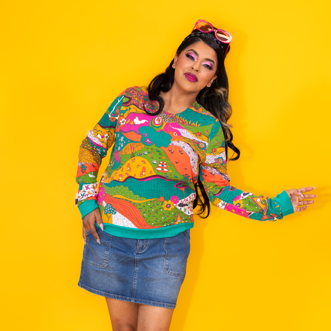 Long-haired model in brightly colored animal print sweatshirt and jean skirt