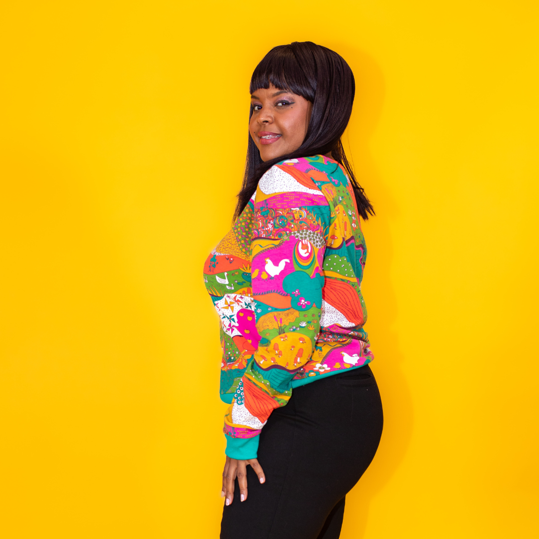 Side view of gorgeous Black model in brightly colored printed sweatshirt and black pants