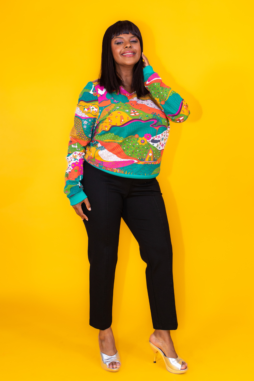 Pretty model in bright colored printed sweatshirt and black pants