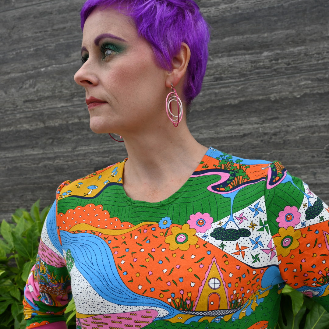 Super close view of purple-haired model in rainbow shirt featuring many fun elements