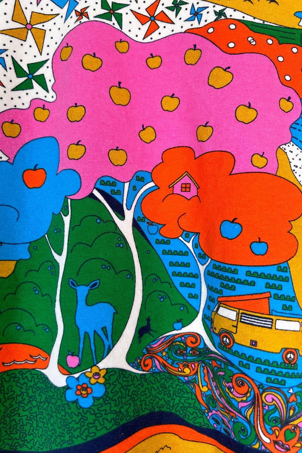 Closeup of rainbow landscape print with trees, deer, and VW bus