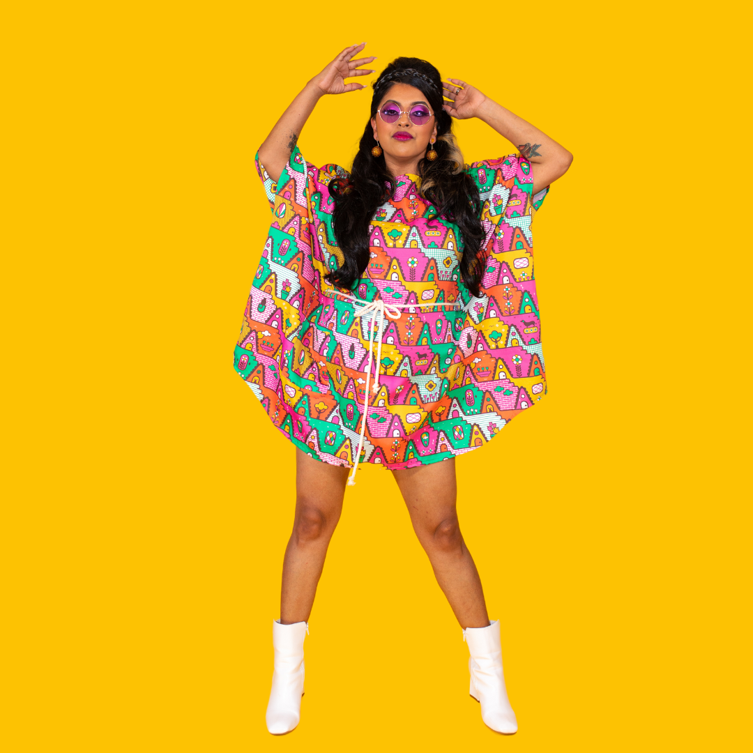 Stunning model in mini muumuu featuring a-frame houses and various animals and foliage