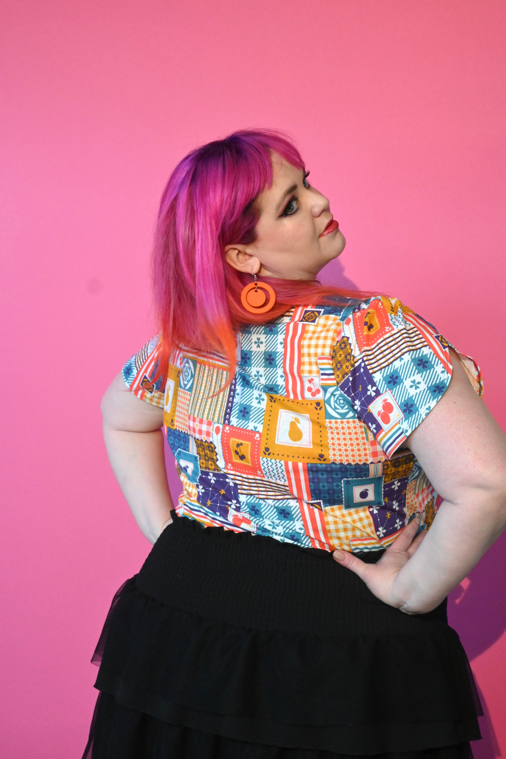 Back view of pink-haired model in patchwork print tulip-sleeved tee