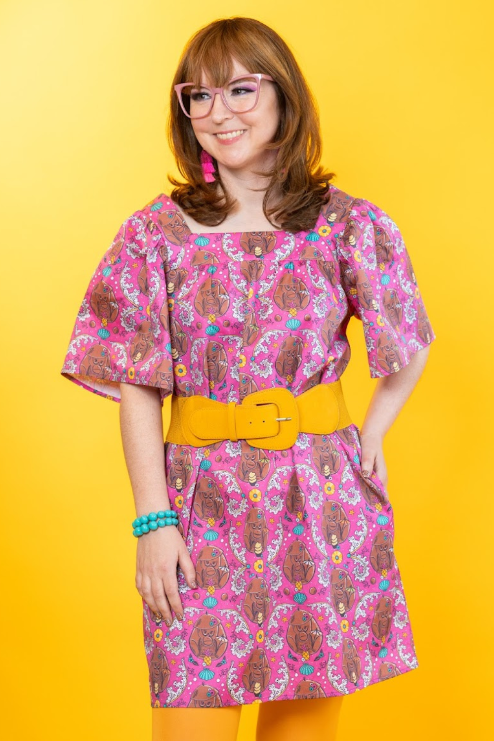 Cute model in magenta dress with monkey print and colorful accessories