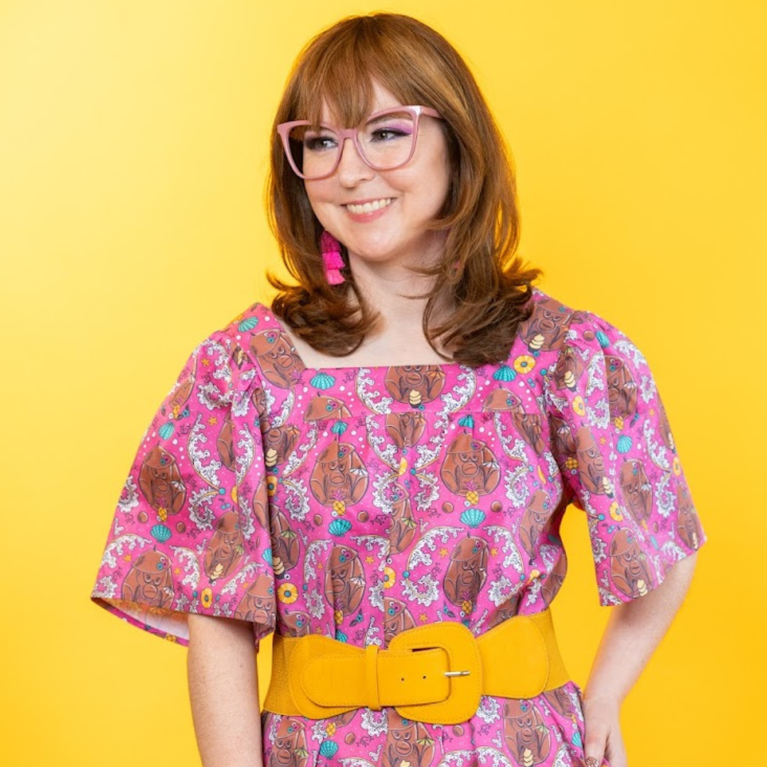 Closeup of cute model in glasses wearing tiki monkey print dress and big belt