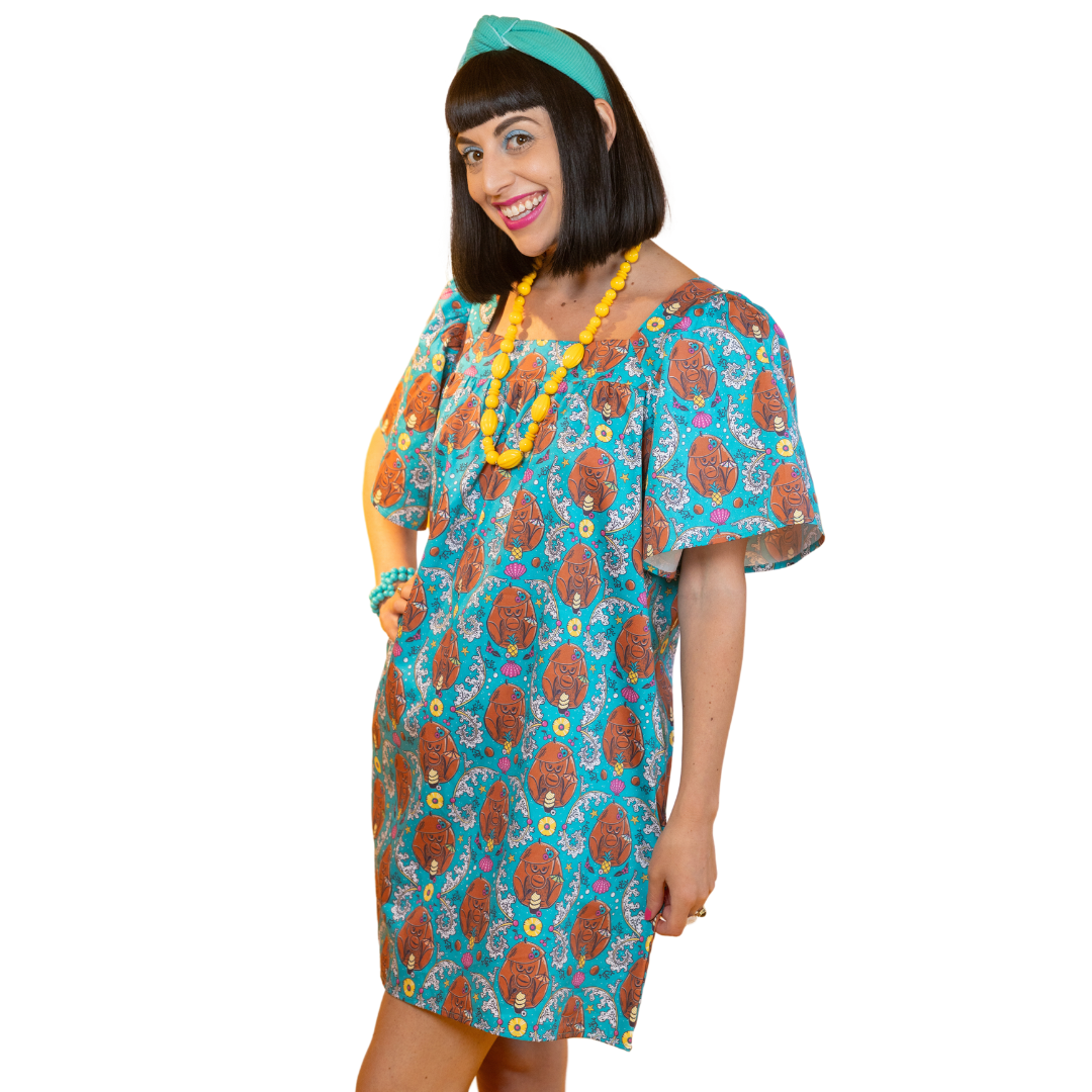 Smiling model in teal mini coconut monkey print dress