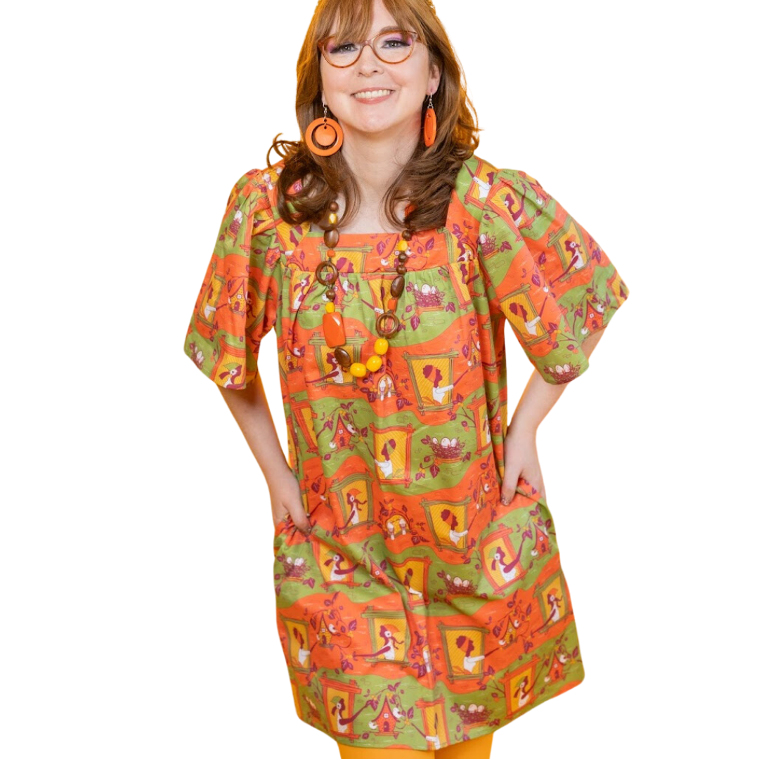 Smiling model in orange and green window girls print square neck cotton dress