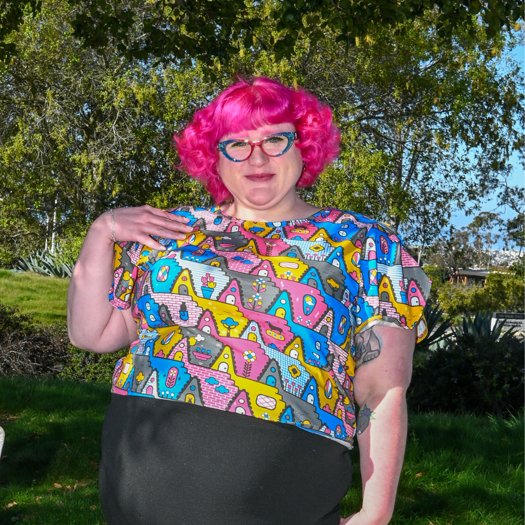 Pink-haired plus sized model in cropped geometric print tulip sleeved tee