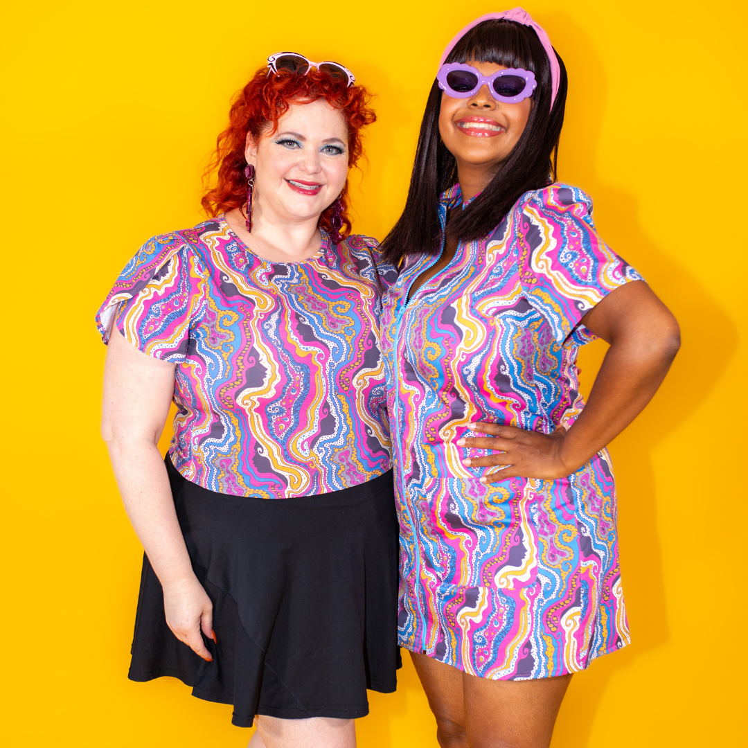 2 girls in matching purple and yellow psychedelic print clothing